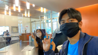 Two masked students giving V-sign