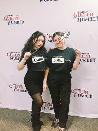 Two students wearing black Guelph-Humber media shirts