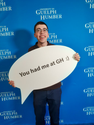 Man holding a sign: 'You had me at GH :)'