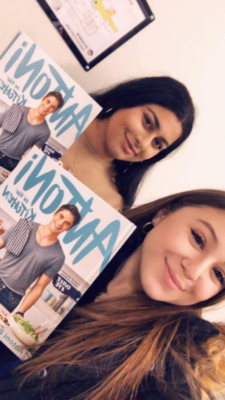 Two students holding up same magazine: 'Antoni in the Kitchen'