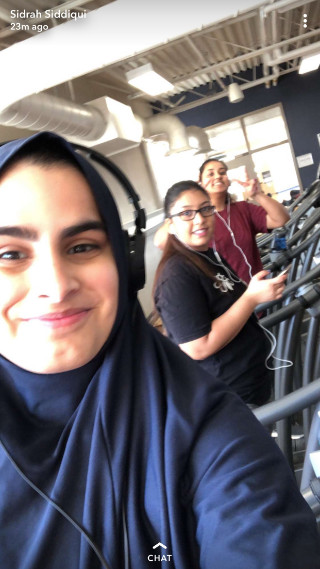 Three students on exercise equipment