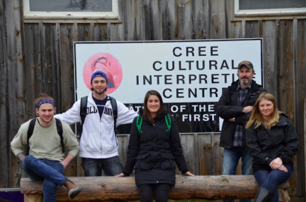 Four people posing in front of Cree Cultural Interpretive Centre
