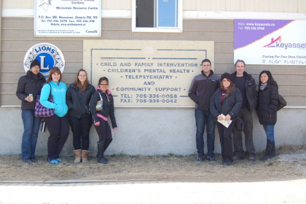 Eight people posing in front of Moosonee Resource Centre
