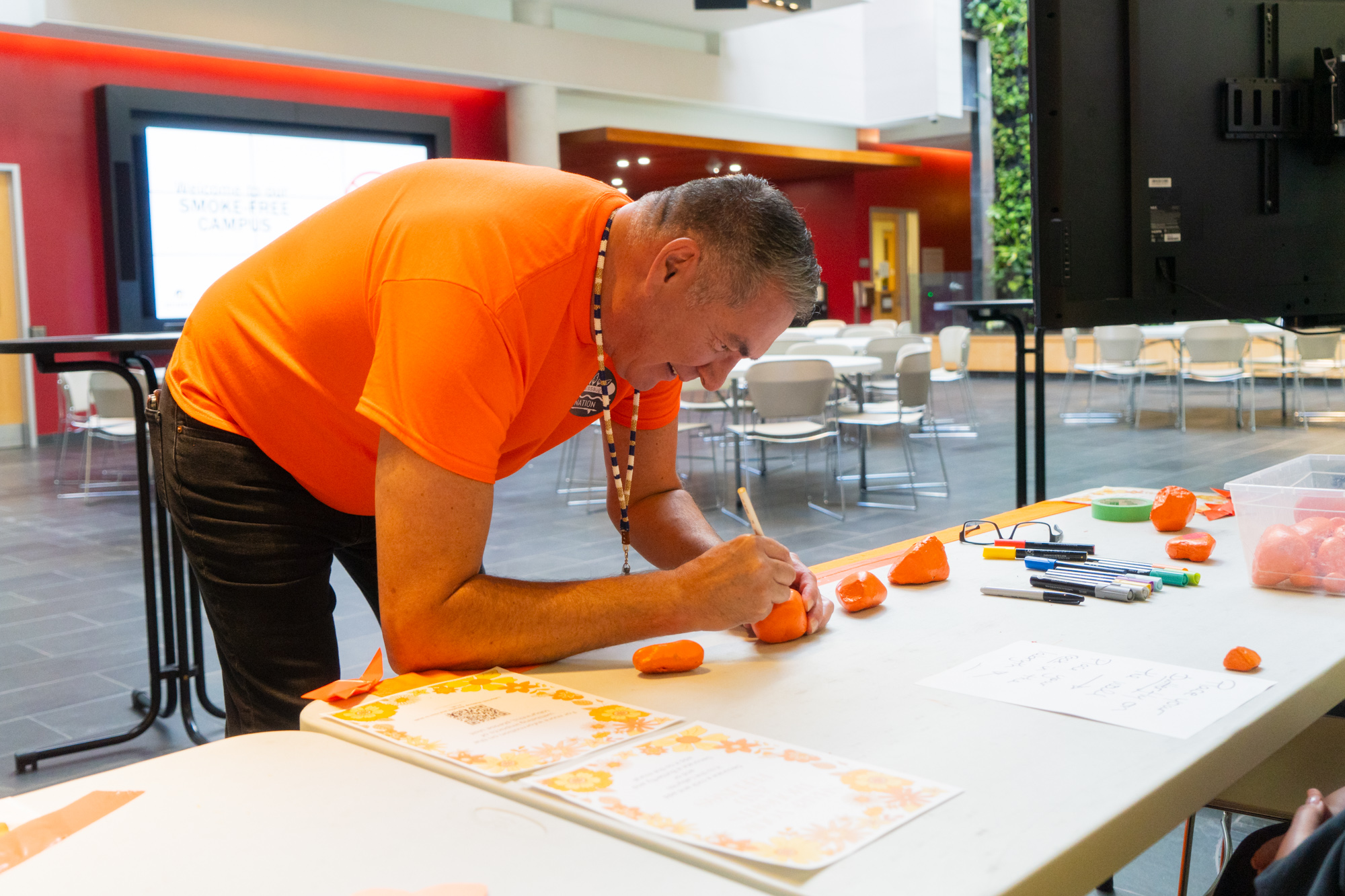 Jason Seright designing a orange painted rock