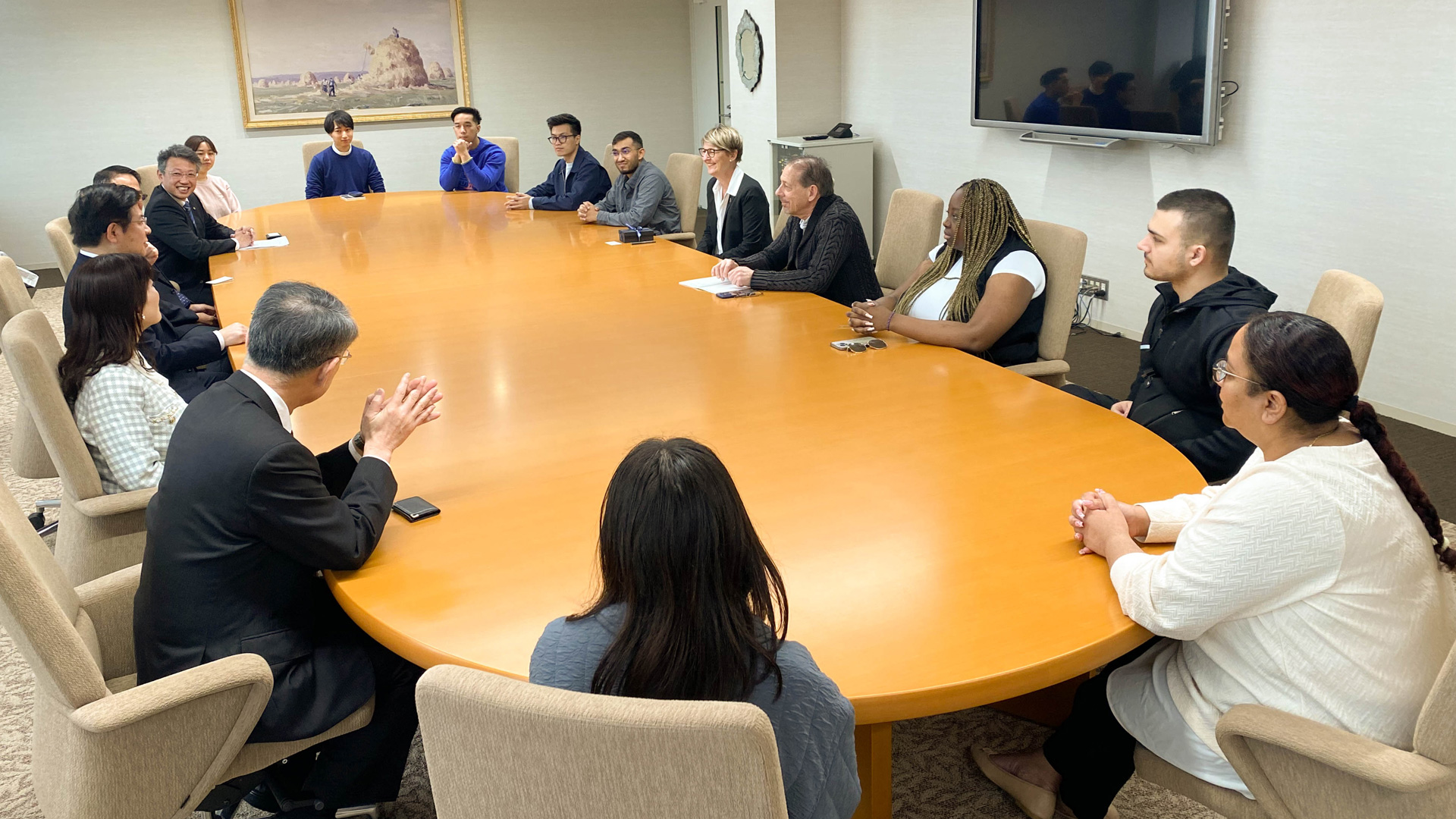 Individuals sitting at a table in a board room