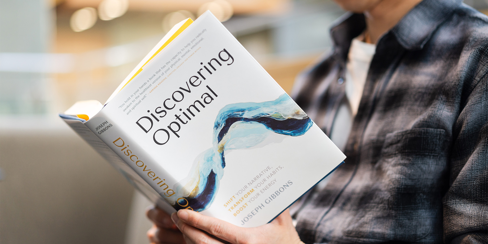 Someone holding a book titled, "Discovering Optimal"