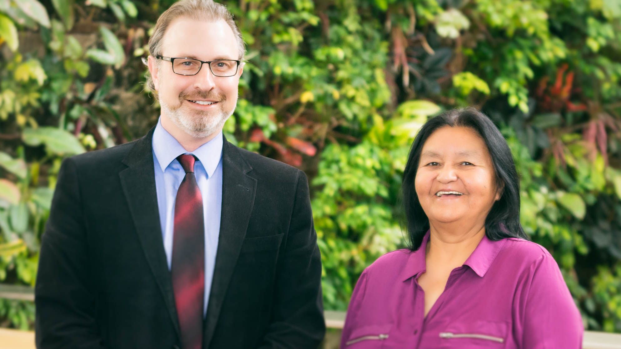 Arlene Faries (left) stands with Dr. David Danto, Program Head of Psychology in front of the UofGH Plant Wall