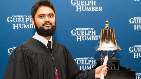 Portrait of Faraz Syed ringing UofGH Bell