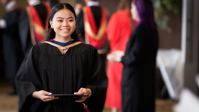 A student walks in her gown