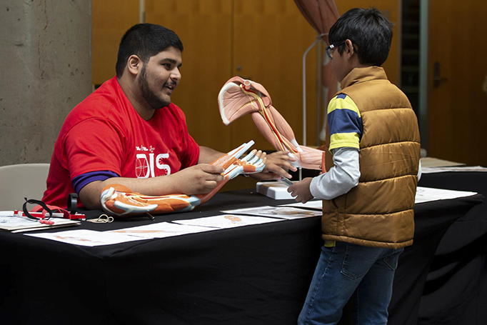 A UofGH volunteer speaking to a youngster