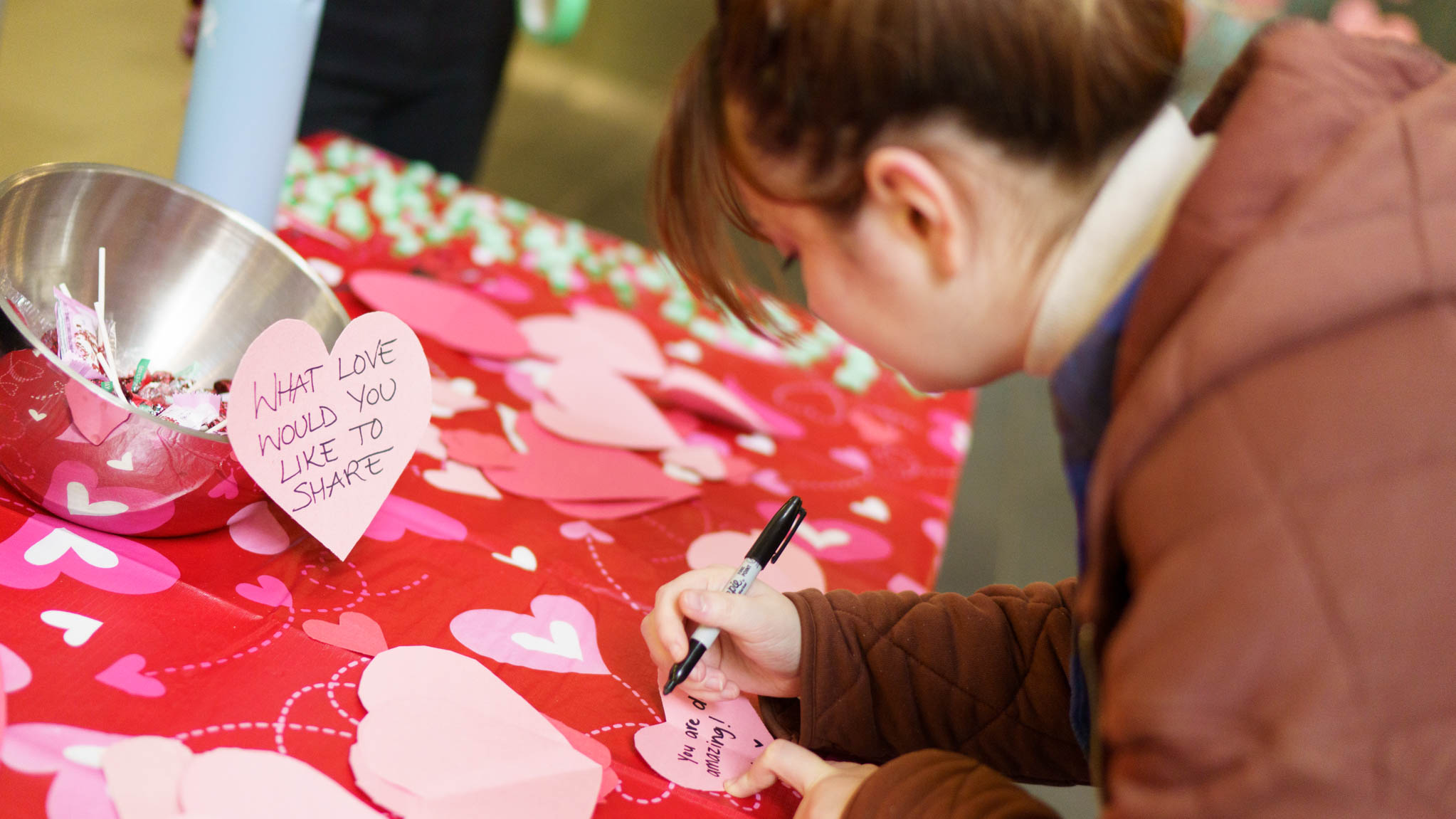 Student writes message on paper heart