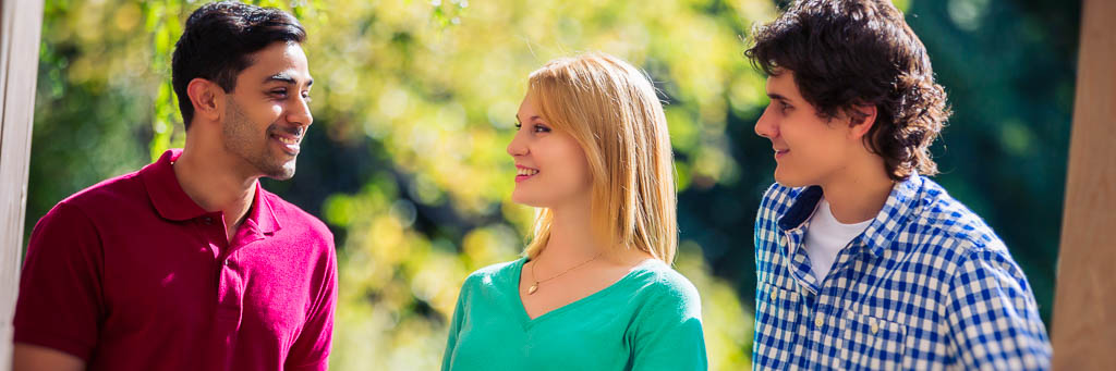 Students talking and smiling in a sunny park