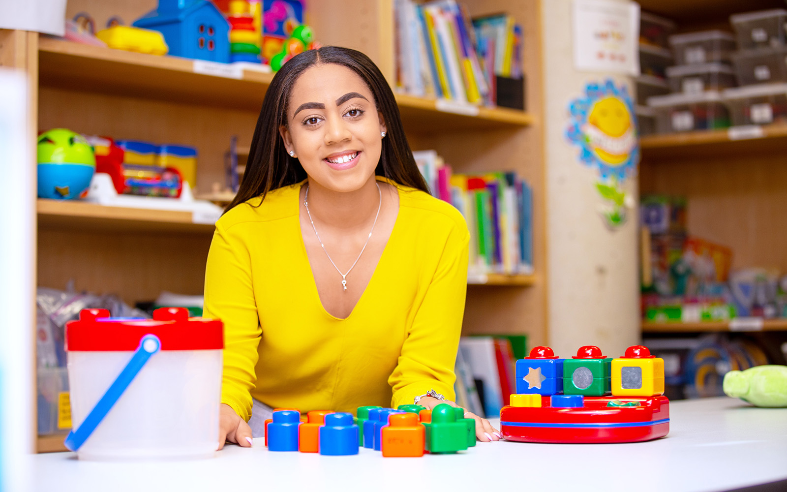 student in front of desk with toy blocks