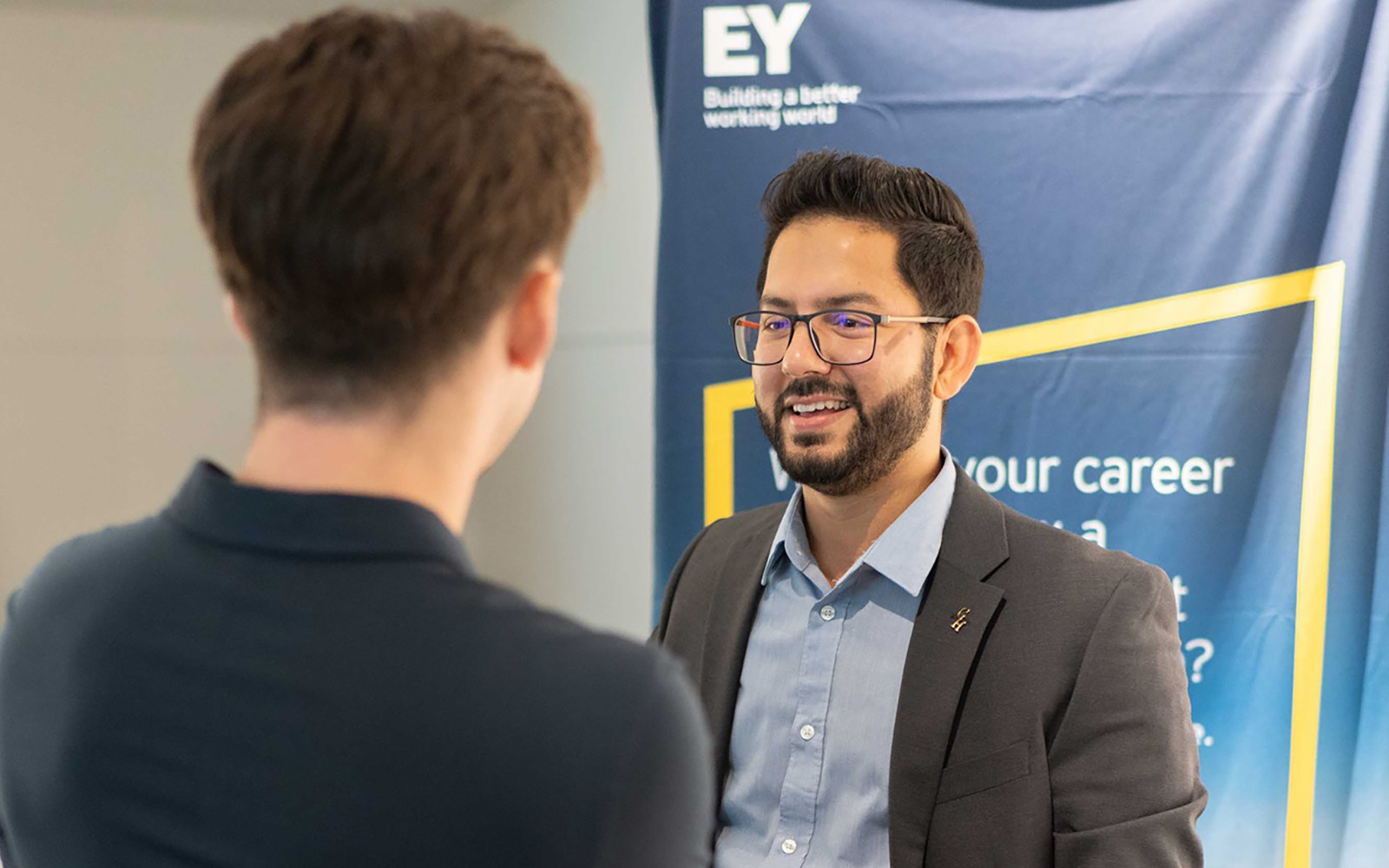mentor in front of EY banner
