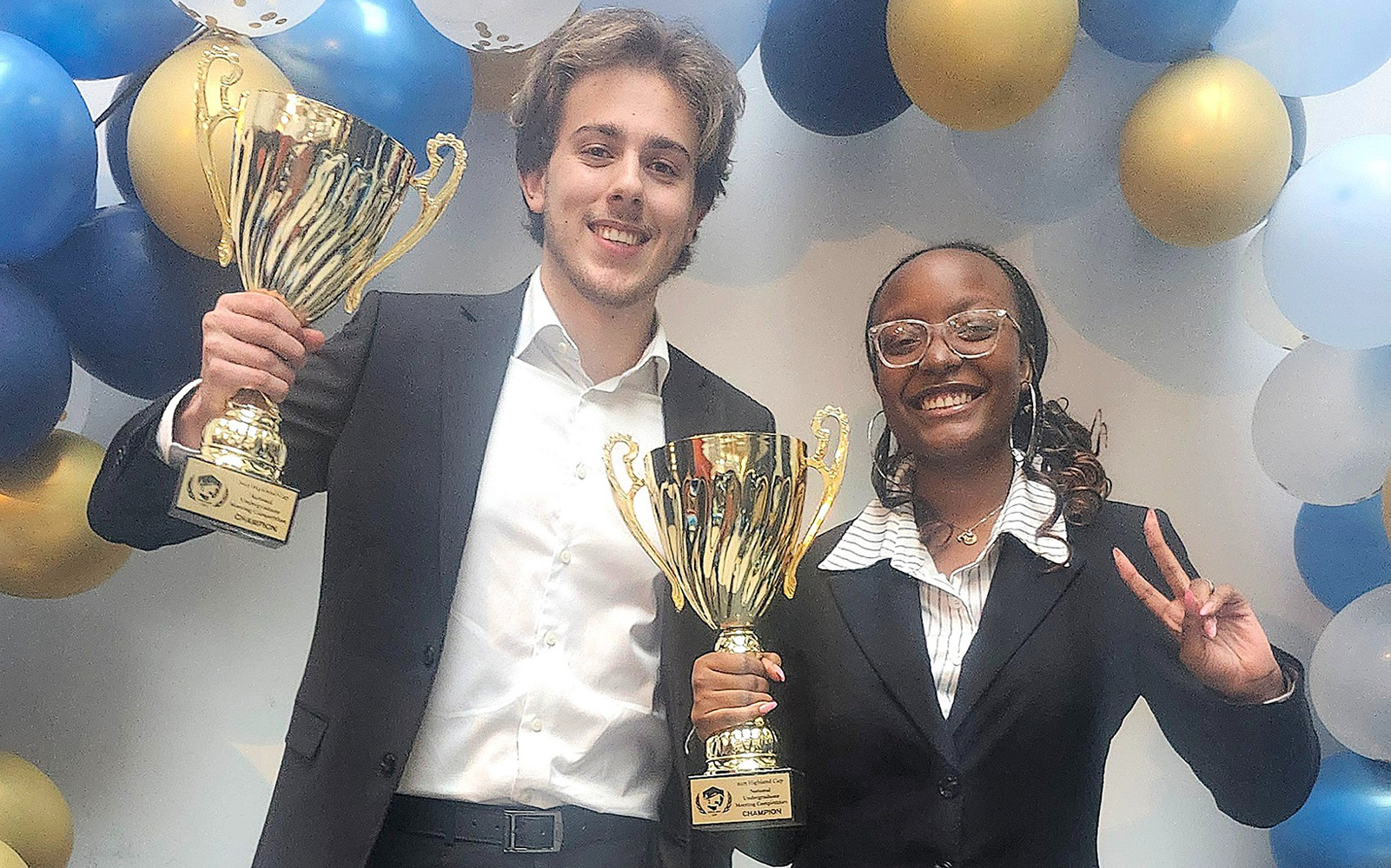Two students holding trophies