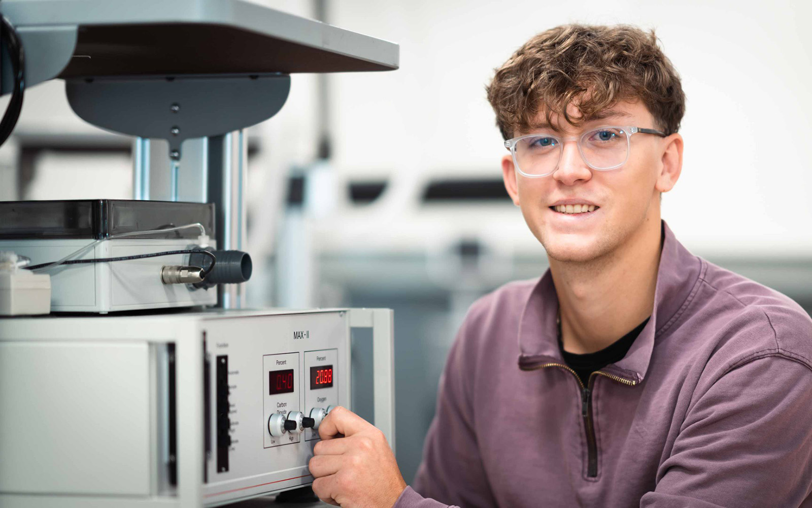student turning a knob on a machine