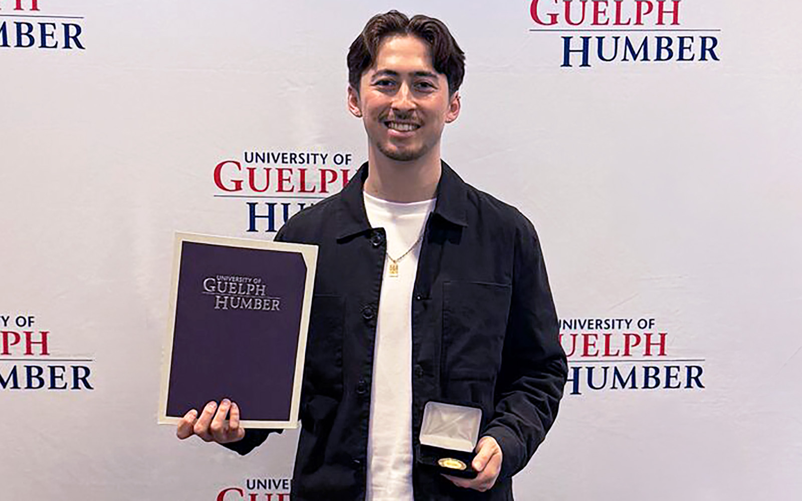 student holding medal