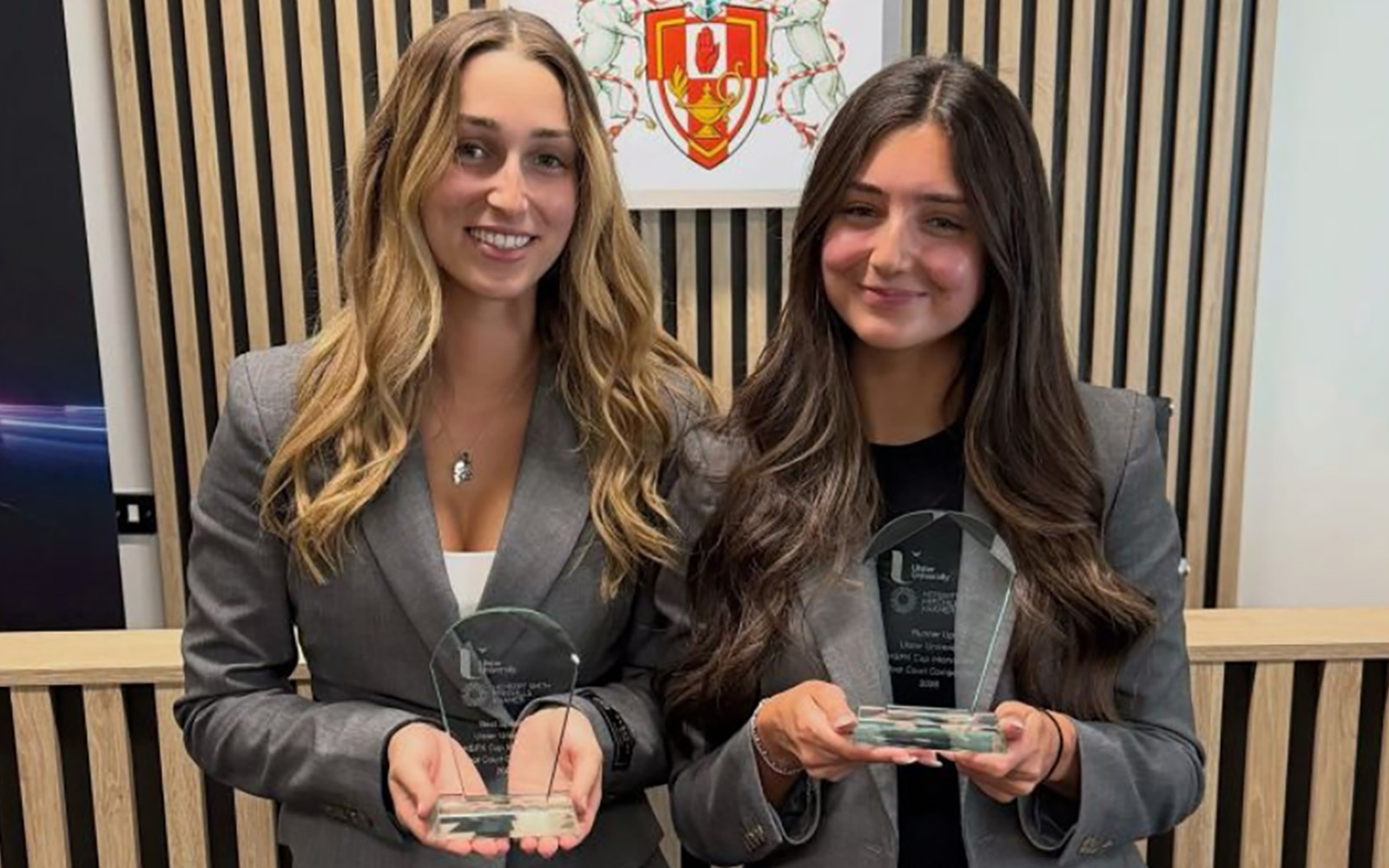 two students holding trophies