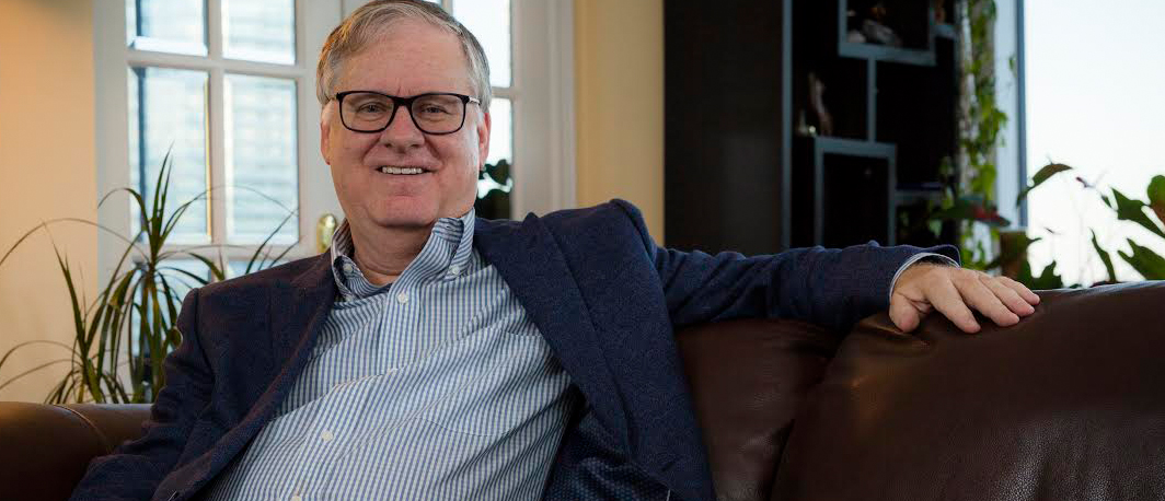 Dr. Dan Andreae smiles on a couch