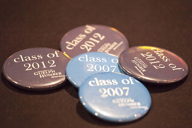 A pile of UofGH alumni buttons