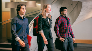 Three students walk across UofGH campus