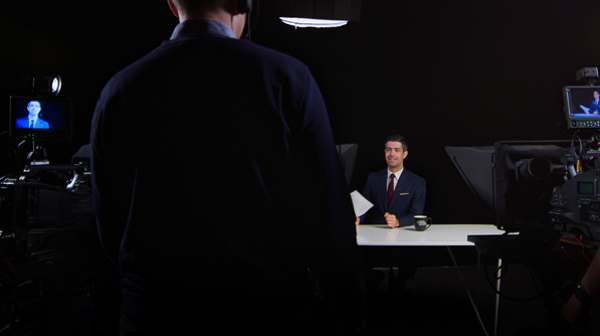 UofGH alum Brendan Dunlop sits at a news desk