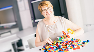 Carri-Ann Scott smiles in front of Lego