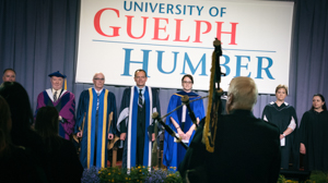 A bagpipe player welcomes graduates
