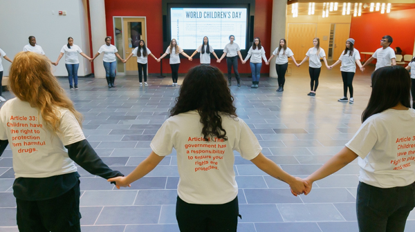 Students hold hands in the atrium