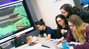 A child assistant helps students play Minecraft