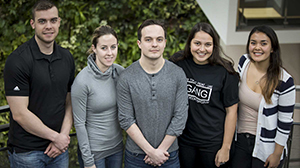 Five UofGH Justice Studies students by the plant wall