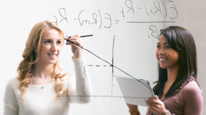 Two students work on a whiteboard