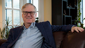 Dr. Dan Andreae smiles on a couch