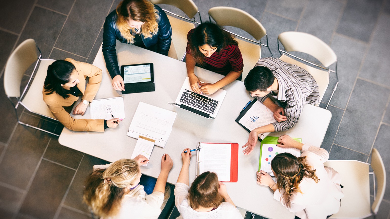 Group of students working at a table bird's eye view from top