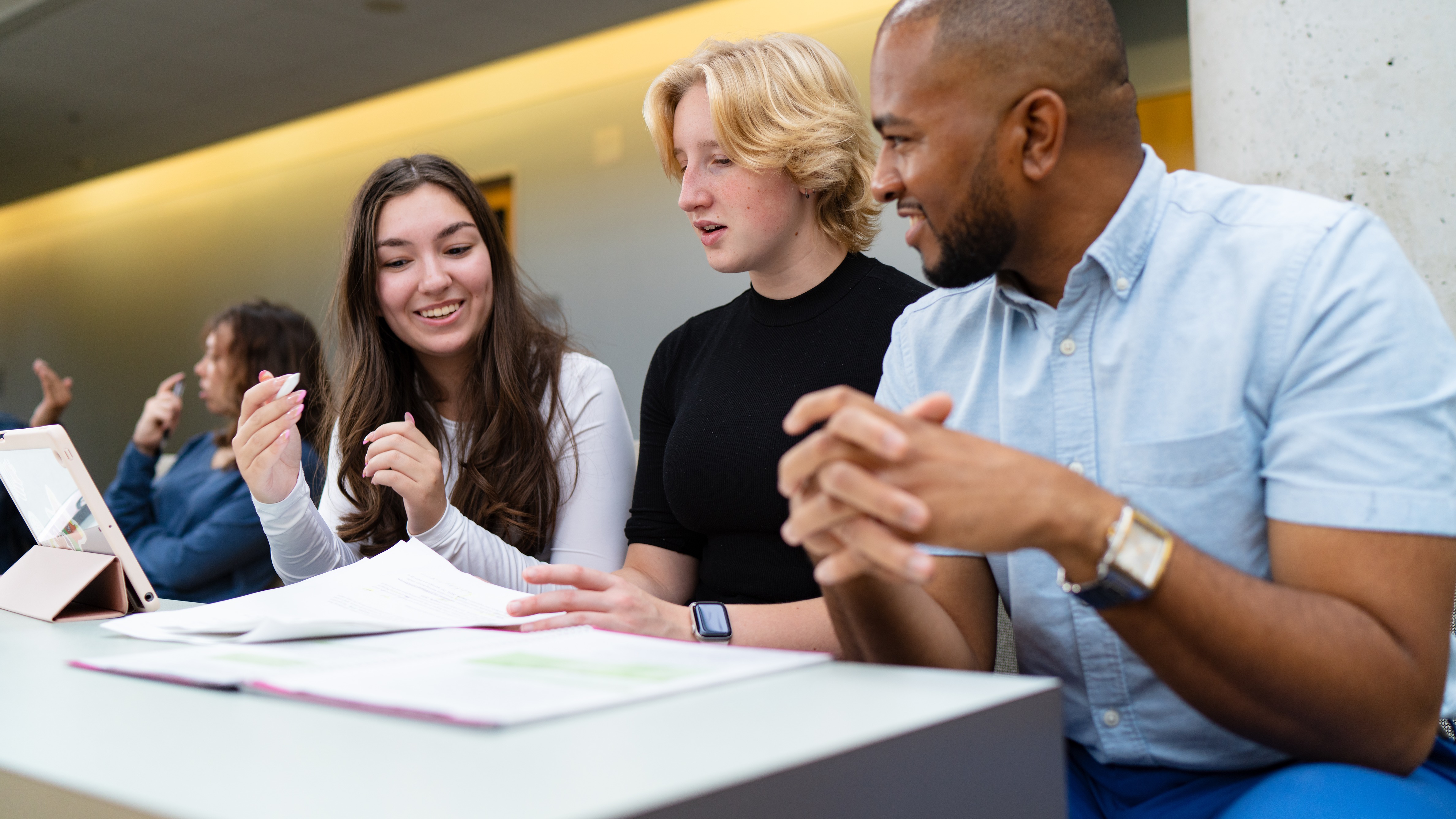 Three students sitting at a desk working together