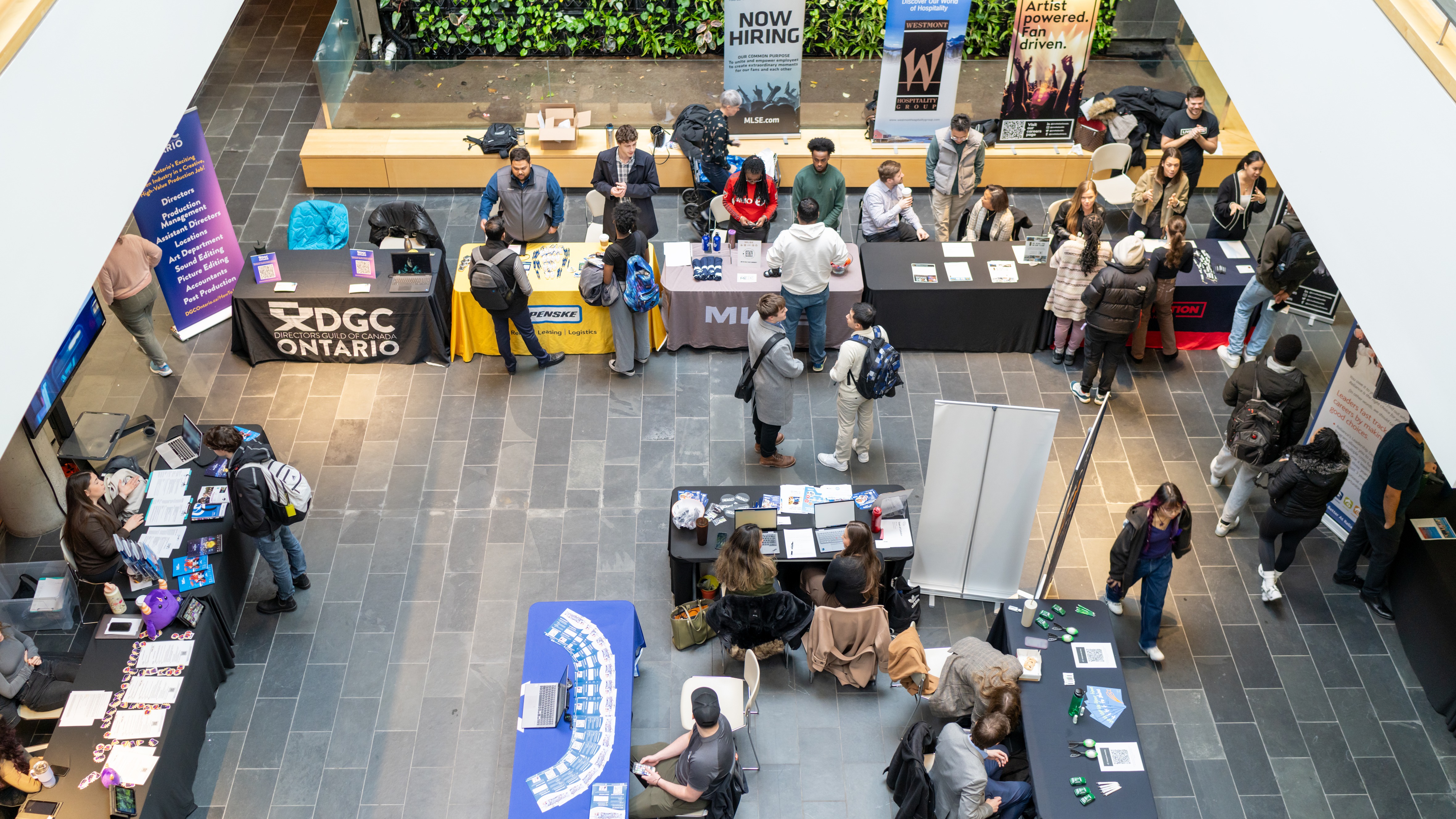 Career fair with tables and people milling, view from above
