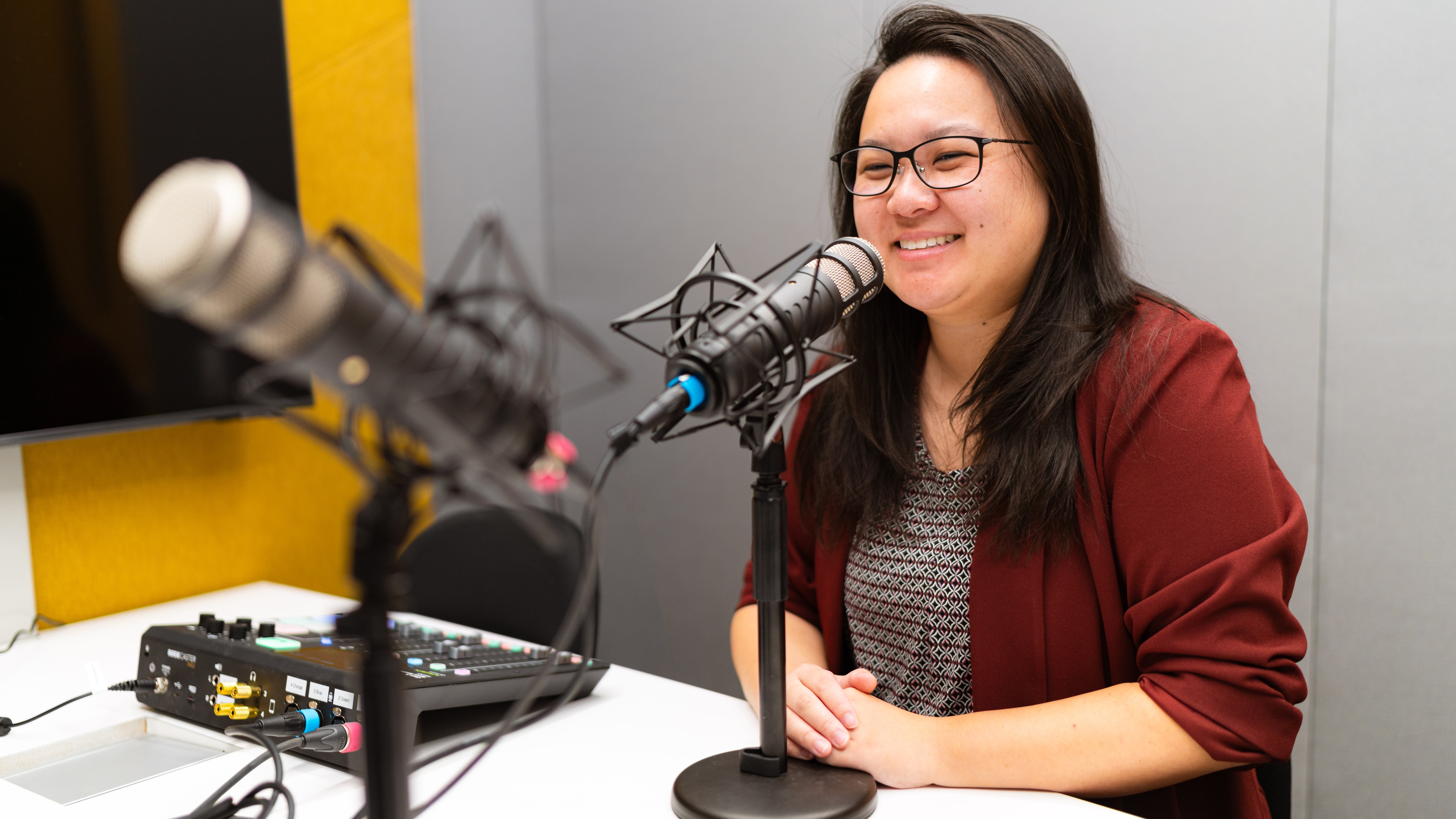 Dr. Victoria Chen in podcast booth with microphone