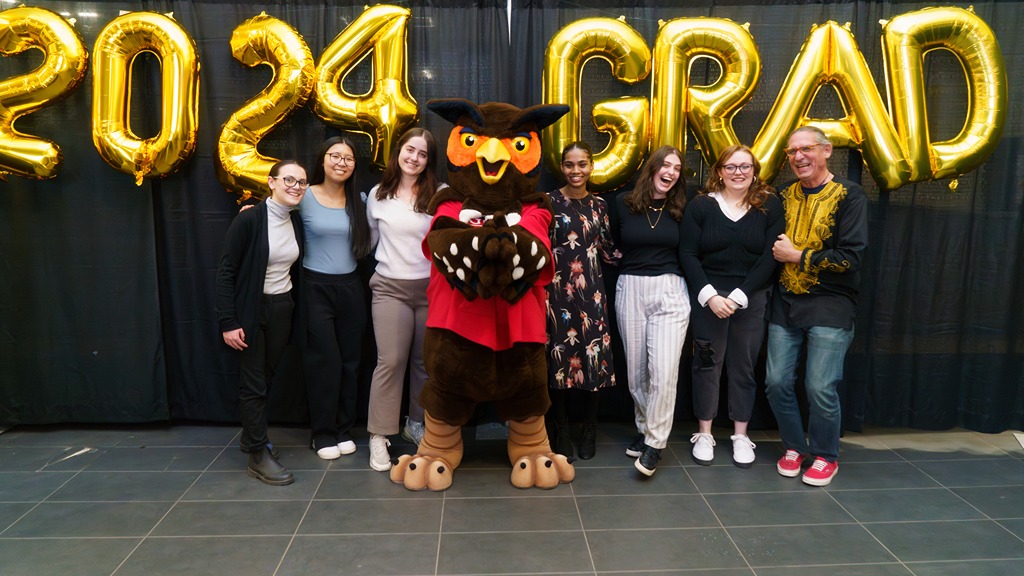 Group of students with Swoop owl mascot with balloons spelling out 2024 Grad