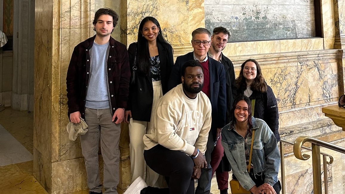 A group of students and faculty member together in front of a piece of art