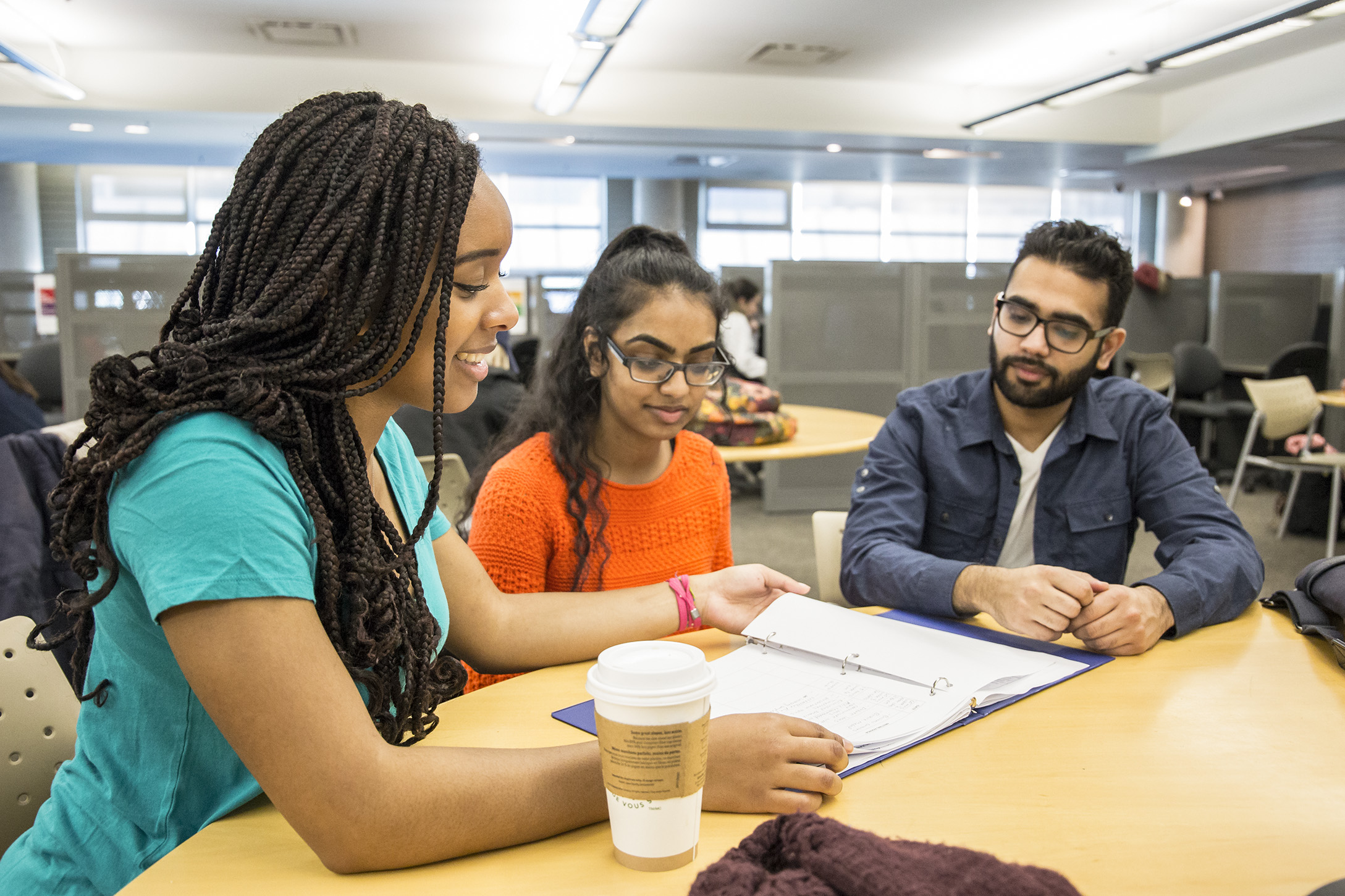 three students studying at desk