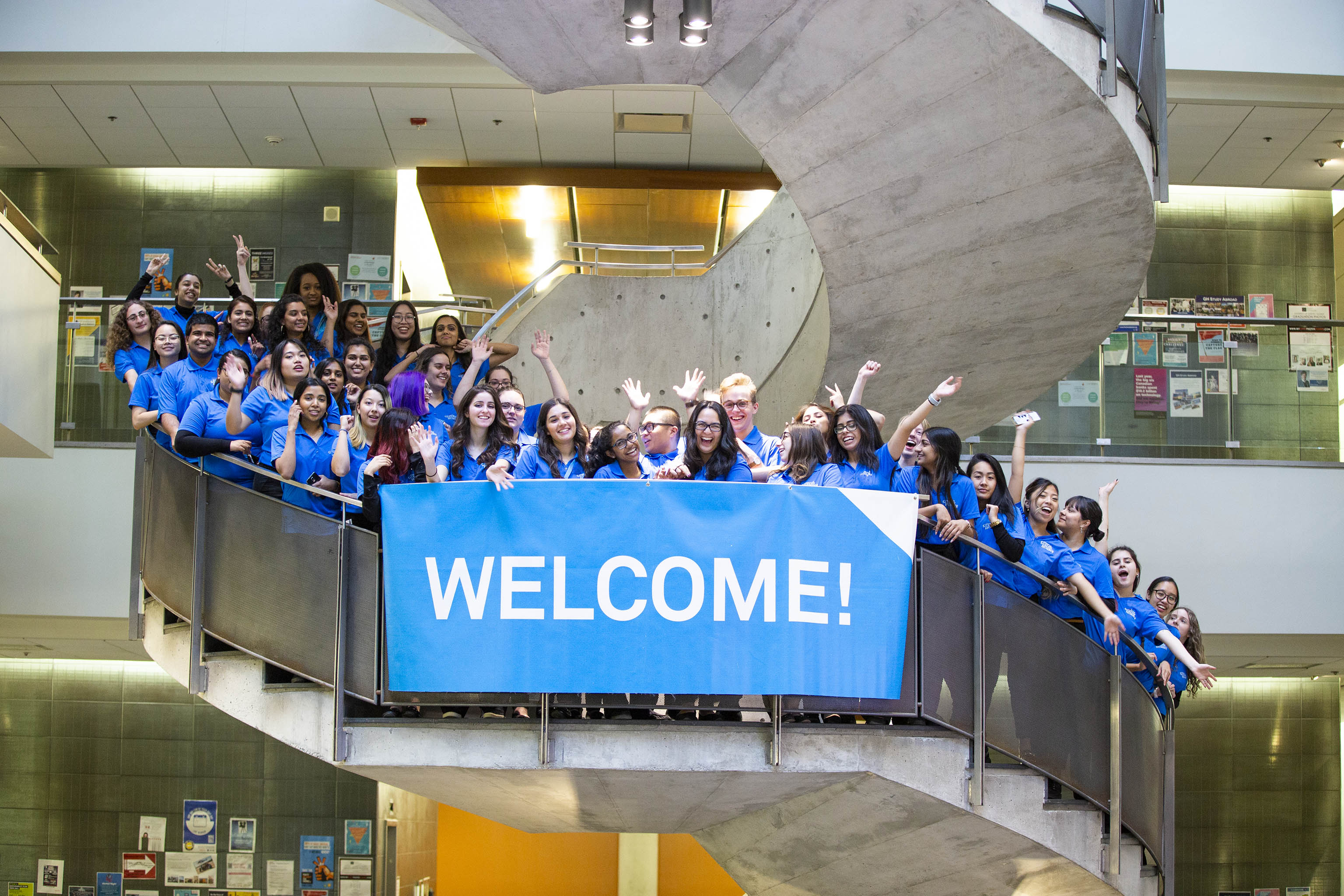 group on staircase with welcome sign