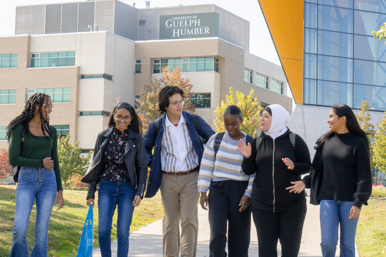 A group of students walk in front of the University of Guelph-Humber.