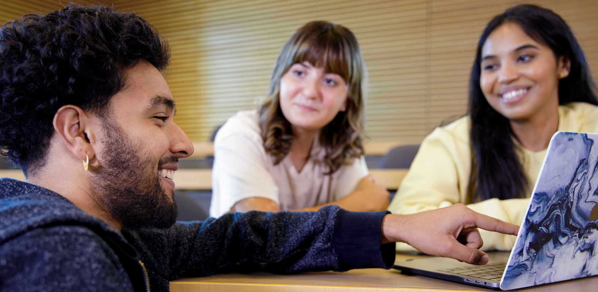 Three students looking at laptop