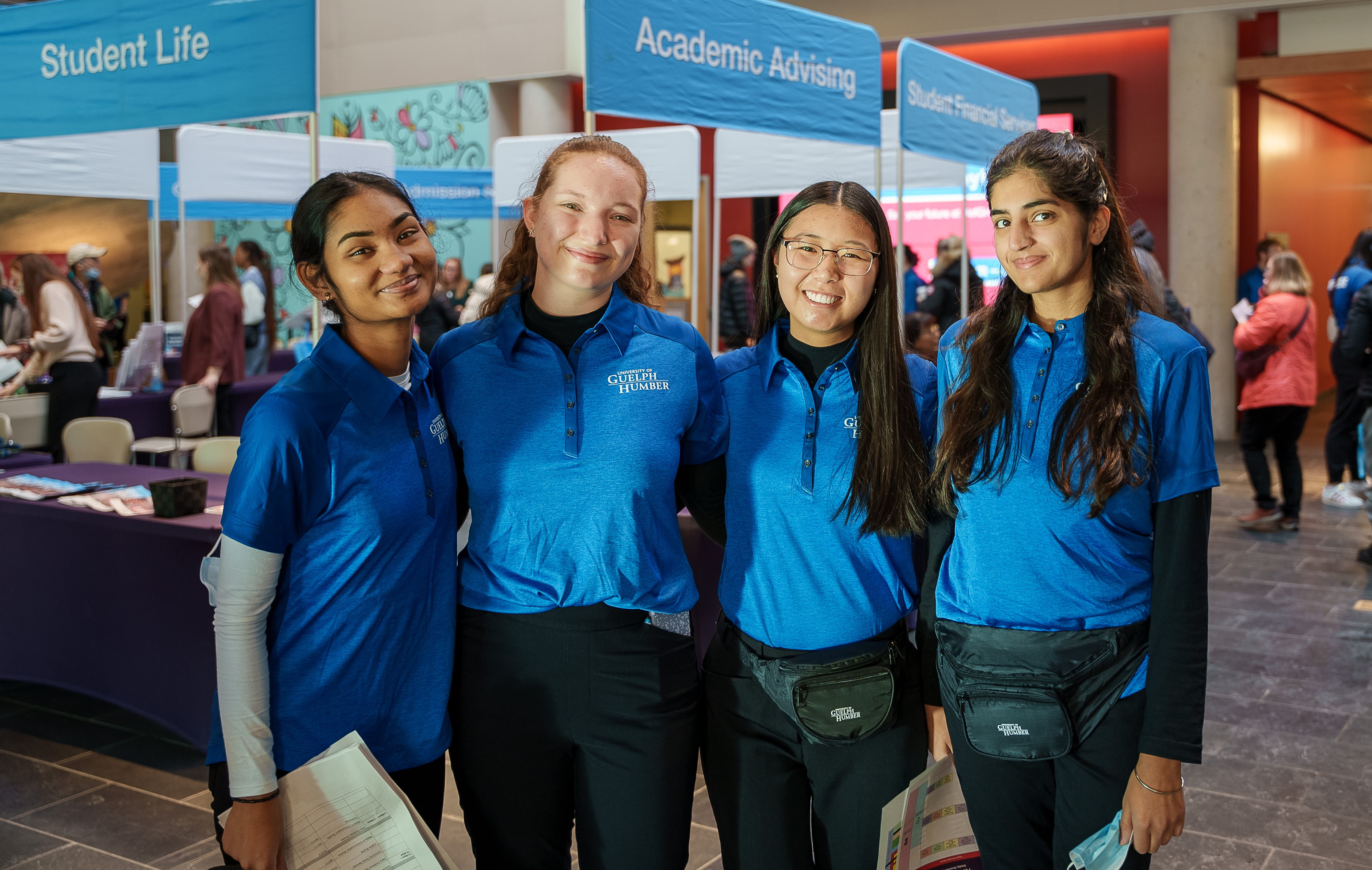 Four students in front of open house booths