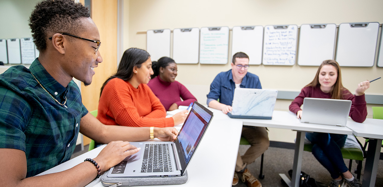 Classroom five students with laptops in classroom