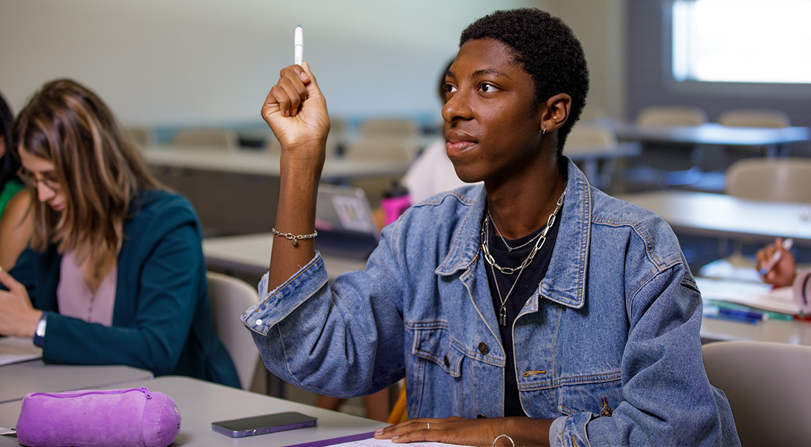 classroom Student holding pen in the air to ask questions