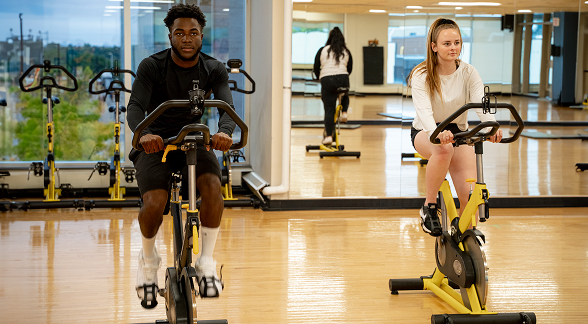 Exercise studio Male and female students on exercise bikes