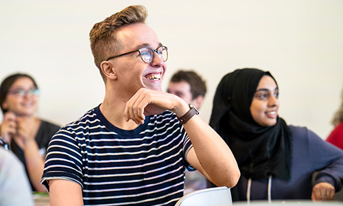 Male student with hand under chin in classroom