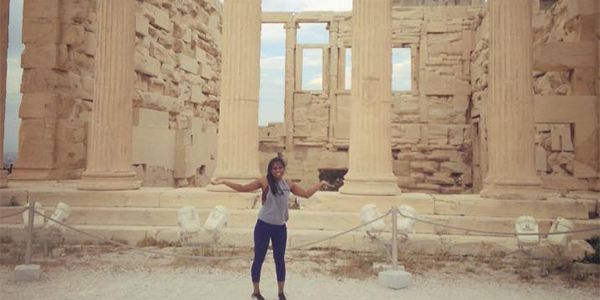 Student standing in front of Greek ruins