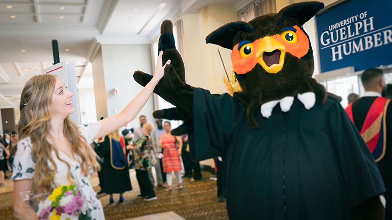 Student shaking giving a hi-five to Swoop